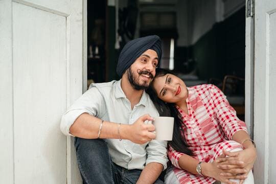 Sikh Male And Female Couple Sitting In Doorway